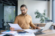 © Liubomir - Focused professional reviewing important paperwork at their desk in a contemporary office setting. Effective workplace organization tools and technology enhance the atmosphere of productivity