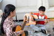 © Andrey - Lifestyle: Boy learning to play acoustic guitar at home