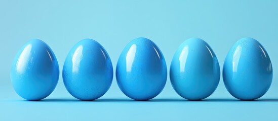 Wall Mural - Vibrant blue Easter eggs arranged neatly on a pastel blue background for spring holiday celebrations and festive decoration themes.