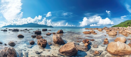 Poster - Rocky beach landscape at low tide under blue skies with clouds featuring stunning coastal scenery and ample copy space for creative use