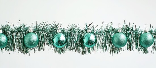 Poster - Christmas decorations shimmering teal ornaments hanging on vibrant tinsel against a clean white backdrop for seasonal design and crafting ideas