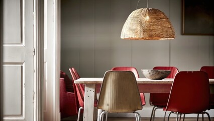 Aufkleber - An openconcept dining area with a large farmhouse table made of reclaimed wood surrounded by mismatched chairs a pendant light made of woven rattan and soft ambient lighting.