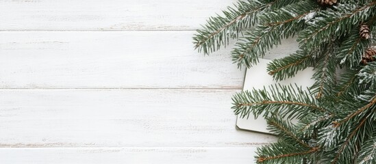 Aufkleber - Christmas tree branch with notebook on white wooden background for holiday planning and festive decoration ideas