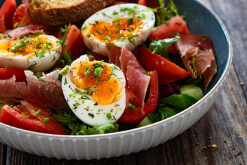 Wall Mural - Fresh salad - dried tuna, boiled eggs, tomatoes and leafy vegetables on wooden table