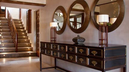 Aufkleber - A contemporary entryway offers a black console table with intricate brass hardware. Decorative brass mirrors line the wall reflecting natural light and creating a sense of