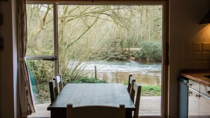 Poster - A dining area with a rustic wooden table surrounded by simple dining chairs and a wide window that opens to the sounds of the babbling brook creating a connection between meals and