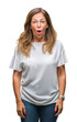 © Krakenimages.com - Middle age senior hispanic woman over isolated background afraid and shocked with surprise expression, fear and excited face.