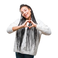 Wall Mural - Young braided hair african american girl wearing sweater over isolated background smiling in love showing heart symbol and shape with hands. Romantic concept.