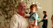 © Marco - Grand-father holding baby grandson in arms