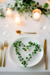 © kazakova0684 - A modern minimalist table with a clean white theme, green sprigs on plates, and golden flatware