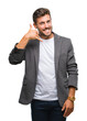 © Krakenimages.com - Young handsome business man over isolated background smiling doing phone gesture with hand and fingers like talking on the telephone. Communicating concepts.