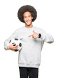 © Krakenimages.com - Young african american man with afro hair holding soccer football ball very happy pointing with hand and finger