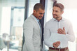 © peopleimages.com - Happy, businessmen and documents with meeting for financial discussion, company budget or proposal at office. Male people, colleagues or employees talking with paperwork for finance report or review