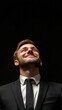 © Marco - man in suit looking up happy on black background with copy space vertically 9:16