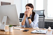 © New Africa - Sick woman with runny nose at table in office