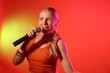 © New Africa - Talented singer performing on red background with yellow light