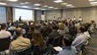 © Samraoy - Business professionals gathered at seminar listening to a presentation in a conference room