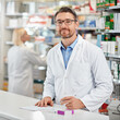 © peopleimages.com - Prescription, drugs and portrait of man in pharmacy with pills, healthcare and medicine box in store. Health insurance, professional service and mature pharmacist writing medical script at counter
