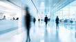 © xinxia - A blurred background of an office with people moving around, glass walls, and white furniture. The focus is on the blurry figures in motion