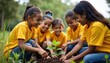 © miss irine - Diverse group of children in yellow shirts plant sapling together. Smiling, engaged in eco-friendly activity. Image community efforts for sustainable environment. Children enjoy planting experience.