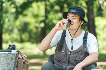 Poster - キャンプ場でキャンプ・グランピングを楽しむ男性（水を飲む）
