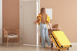 © Pixel-Shot - Young woman with suitcase opening door in hotel room