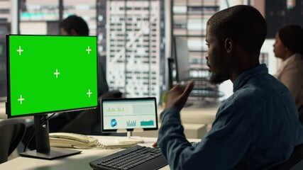 Poster - male administrator focused on financial planning next to chroma key screen, reviewing infographics f