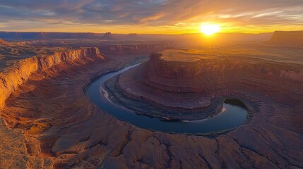 Poster - As the sun sets over the rugged landscape, a winding river reflects golden hues while carving its path through dramatic canyons, creating a mesmerizing view filled with tranquility