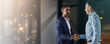 © BuyoutReese09/peopleimages.com - Deal, handshake and partnership with business men in office for meeting, thank you or welcome. Banner, bokeh and mockup with employee people shaking hands for onboarding or recruitment on space