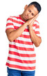 © Krakenimages.com - Young handsome latin man wearing casual clothes sleeping tired dreaming and posing with hands together while smiling with closed eyes.