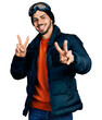 © Krakenimages.com - Young hispanic man with beard wearing snow wear and sky glasses smiling looking to the camera showing fingers doing victory sign. number two.