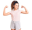 © Krakenimages.com - Beautiful kid girl with curly hair wearing casual clothes showing arms muscles smiling proud. fitness concept.