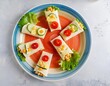 © João Macedo - Kids breakfast, chickpea and cucumber wraps decorated with tomatoes on colorful plate