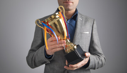 Wall Mural - Man holding a winner golden trophy cup.