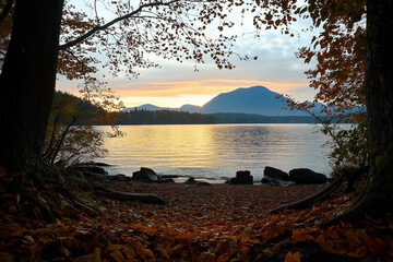 Wall Mural - sunset over a lake with mountain view framed by autumn trees and fallen leaves. fall background