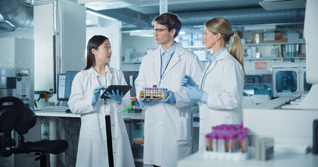 Leinwandbilder - Portrait of a Diverse Research Team Standing in a Modern Laboratory in White Coats. Female and Male Scientists Discuss Findings, Hold Test Samples and Use Tablet