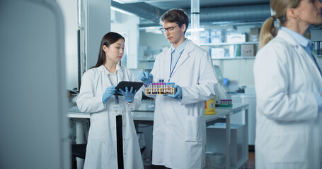 Leinwandbilder - Research Team Working on Medical Drug Development in a Scientific Laboratory with Advanced Equipment. Asian Female and Young Male Scientists Discuss Online Data on Tablet, Talk and Handle Samples
