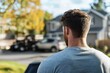 © Milos - A man stands outdoors, thoughtfully gazing at the neighborhood, showcasing an introspective moment that evokes contemplation and serenity amidst a suburban backdrop.