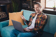 © deagreez - Young man enjoying leisure time at home in a stylish living room with laptop on couch