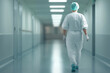© Mselected - Healthcare worker walking down quiet hospital corridor in sterile uniform