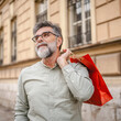 © Miljan Živković - Portrait of smile senior man with shopping bags on the street
