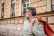 © Miljan Živković - senior man hold shopping bags and looking for somebody on the street