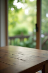 Poster - The top of a wooden table sits atop a blurred window frame with a glimpse of the garden outside in the background._00002_