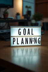 Poster - Text about goal planning and action is displayed on a light box at the home office workspace near a desk table._00002_