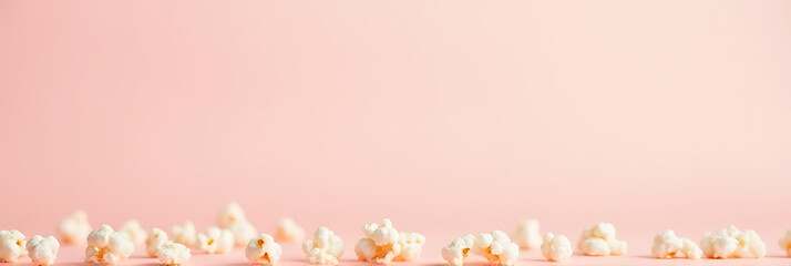 Poster - Popcorn kernels are scattered across a soft pastel color background to create a simplistic food concept idea for snacks._00001_