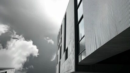 Poster - Explore the beauty of contemporary architecture as tall buildings converge, creating a dramatic view of clouds and glass