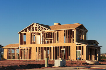 Wall Mural - A full view of the wooden framing of a two-story, single-family home under construction in a new housing development