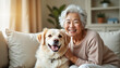© Alex_Kalin - Joyful moments between a smiling elderly woman and her cheerful dog on a cozy couch in a sunlit living room