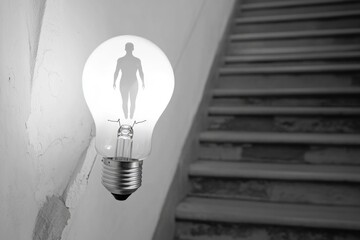 Poster - A light bulb with a silhouette of a person, great for use in illustrations or designs related to people and technology