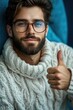 © Ева Поликарпова - A man with a beard and glasses gives a thumbs up, a positive gesture
